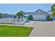 Charming home with a white picket fence, lush lawn, tropical palm, and welcoming outdoor seating area at 214 Lookout Dr, Apollo Beach, FL 33572