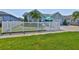 Charming home with a white picket fence, lush lawn, tropical palm, and welcoming outdoor seating area at 214 Lookout Dr, Apollo Beach, FL 33572