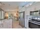 Kitchen with stainless steel appliances and white cabinetry flows to open living area at 214 Lookout Dr, Apollo Beach, FL 33572