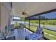 Screened lanai with outdoor furniture, fan, and privacy shades, overlooking the landscaped yard at 214 Lookout Dr, Apollo Beach, FL 33572