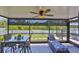 Enclosed lanai features a ceiling fan, outdoor dining set, and a cozy lounge area with a view of the yard at 214 Lookout Dr, Apollo Beach, FL 33572
