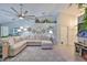 Open concept living room with a sectional couch, ceiling fan, fireplace, and stylish decor at 214 Lookout Dr, Apollo Beach, FL 33572