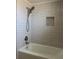 Modern bathroom with tiled walls, a shower head, and a built-in niche for storage at 2551 12Th St, Englewood, FL 34224