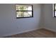 A bedroom with wood floors, white walls, and a window looking out to backyard trees at 2551 12Th St, Englewood, FL 34224