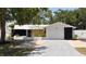 Charming single-story home featuring lush landscaping, a brick driveway, and a white exterior at 2551 12Th St, Englewood, FL 34224
