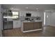 Bright kitchen featuring stainless steel appliances, white cabinets, and an island with seating at 2551 12Th St, Englewood, FL 34224