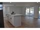 Modern kitchen with a large island, wood floors, and sliding glass doors to the outdoor patio at 2551 12Th St, Englewood, FL 34224
