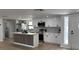 Bright kitchen with white cabinets, stainless steel appliances, and an island with a modern wood accent at 2551 12Th St, Englewood, FL 34224