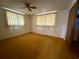 A simple bedroom with two windows covered with curtains and carpeting at 3035 Coldwell Dr, Holiday, FL 34691