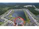 Aerial view of a neighborhood featuring homes surrounding a large lake and green spaces at 3063 Marine Grass Dr, Wimauma, FL 33598