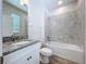 Bathroom with granite countertop vanity, a toilet, and a tiled shower/tub at 3063 Marine Grass Dr, Wimauma, FL 33598