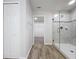 Bathroom features wood-look tile, a glass-enclosed shower, and a closet in the background at 3063 Marine Grass Dr, Wimauma, FL 33598