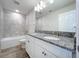 Bright bathroom with a double granite vanity, tile flooring, and a tiled shower-tub combo at 3063 Marine Grass Dr, Wimauma, FL 33598