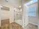 Bathroom featuring a glass shower with tile surround and wood-look tile flooring at 3063 Marine Grass Dr, Wimauma, FL 33598