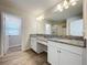 Bathroom featuring double vanity with granite countertops, wood-look floors and large mirror at 3063 Marine Grass Dr, Wimauma, FL 33598