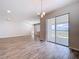 Open dining area with sliding glass doors leading to a patio and wood-look tile flooring at 3063 Marine Grass Dr, Wimauma, FL 33598