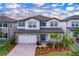 Two-story home featuring a brick-accented garage, well-manicured landscaping, and a contrasting front door at 3063 Marine Grass Dr, Wimauma, FL 33598