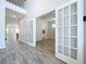 Open foyer with wood-look tile floors and glass paneled doors leading to a separate room at 3063 Marine Grass Dr, Wimauma, FL 33598