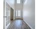 Bright foyer with high ceilings, wood-look tile flooring, and a clear view of the front door at 3063 Marine Grass Dr, Wimauma, FL 33598