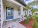 Charming front entrance with a blue door, covered porch, and well-maintained landscaping at 3063 Marine Grass Dr, Wimauma, FL 33598