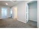 Hallway with multiple doors and neutral carpet flooring throughout the house at 3063 Marine Grass Dr, Wimauma, FL 33598