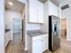 Bright kitchen with granite countertops, stainless steel refrigerator, and wood-look tile floors at 3063 Marine Grass Dr, Wimauma, FL 33598