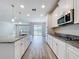 Modern kitchen with stainless steel appliances, granite countertops, island, and wood-look flooring at 3063 Marine Grass Dr, Wimauma, FL 33598