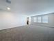 Expansive living room with plush carpet, recessed lighting, and large windows at 3063 Marine Grass Dr, Wimauma, FL 33598