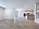 Open concept kitchen and living space with wood-look tile flooring and lots of natural light at 3063 Marine Grass Dr, Wimauma, FL 33598