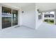 Covered patio features sliding glass doors to the interior and sleek outdoor lighting at 3063 Marine Grass Dr, Wimauma, FL 33598