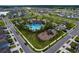 Aerial view of the community pool, playground, and surrounding neighborhood at 3063 Marine Grass Dr, Wimauma, FL 33598