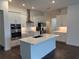 Modern kitchen with stainless steel appliances, quartz countertops, and a center island with a sink at 31602 Cardinal Yard Dr, San Antonio, FL 33576