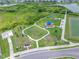 Aerial view showcases a well-manicured neighborhood park with playground and open spaces at 31775 Sun Kettle Loop Loop, Wesley Chapel, FL 33545