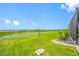 Backyard view featuring lush green lawn and serene waterfront scenery in the distance at 31775 Sun Kettle Loop Loop, Wesley Chapel, FL 33545
