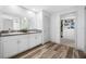 Well-lit bathroom with double sinks, granite countertops, white cabinets, and a view of the walk-in closet at 31775 Sun Kettle Loop Loop, Wesley Chapel, FL 33545