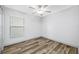 A clean bedroom with a window, ceiling fan, and wood-look flooring at 31775 Sun Kettle Loop Loop, Wesley Chapel, FL 33545