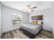 Cozy bedroom featuring a ceiling fan, natural light, and wood-look flooring at 31775 Sun Kettle Loop Loop, Wesley Chapel, FL 33545