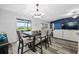 Open dining area boasts an elegant chandelier, wood floors, a view of the pool, and access to the living room at 31775 Sun Kettle Loop Loop, Wesley Chapel, FL 33545