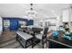 Bright dining area features a modern chandelier, gray wood floors, a dark wood table, and a stylish blue accent wall at 31775 Sun Kettle Loop Loop, Wesley Chapel, FL 33545