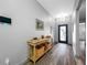 Bright entryway with wood-look flooring, a console table, wall art, and a blue front door at 31775 Sun Kettle Loop Loop, Wesley Chapel, FL 33545