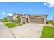 Single-story home with neutral exterior, manicured lawn, and a spacious driveway at 31775 Sun Kettle Loop Loop, Wesley Chapel, FL 33545