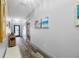 Hallway with wood-look floors, light gray walls, and beach-themed art leading to the front door at 31775 Sun Kettle Loop Loop, Wesley Chapel, FL 33545