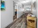 Hallway with wood-look floors leading to the bedrooms, living room, and entryway with console table at 31775 Sun Kettle Loop Loop, Wesley Chapel, FL 33545