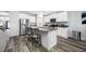 Modern kitchen with white cabinets, stainless steel appliances, and a granite countertop island at 31775 Sun Kettle Loop Loop, Wesley Chapel, FL 33545