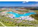 Expansive aerial view of a lagoon and a community with palm trees, white sandy beach, and clear blue water at 31775 Sun Kettle Loop Loop, Wesley Chapel, FL 33545