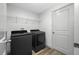 Bright laundry room features a modern washer and dryer set, and wire shelving for storage at 31775 Sun Kettle Loop Loop, Wesley Chapel, FL 33545