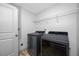 Clean laundry room features a modern washer and dryer set, and wire shelving for storage at 31775 Sun Kettle Loop Loop, Wesley Chapel, FL 33545