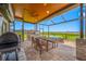 Beautiful screened-in patio with outdoor dining and kitchen area overlooking a serene landscape at 31775 Sun Kettle Loop Loop, Wesley Chapel, FL 33545