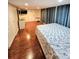 Spacious bedroom with wood floors, featuring a dresser and large windows with curtains at 33516 Arthur Dr, Wesley Chapel, FL 33543