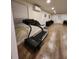 Large bonus room showcasing a treadmill, tile flooring, and a split AC unit at 33516 Arthur Dr, Wesley Chapel, FL 33543